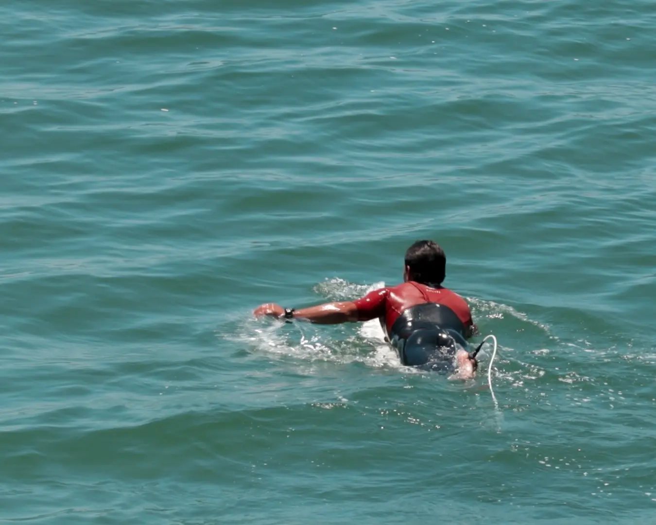 Man paddles in ocean